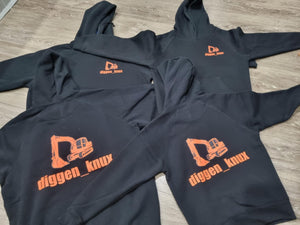 Black hoodies with orange logos and text on a wooden floor